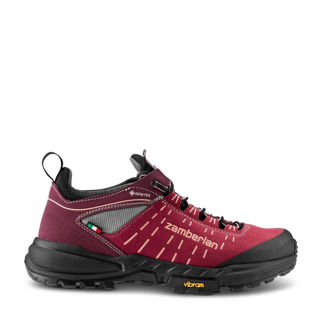 Red hiking shoe with black sole on a white background