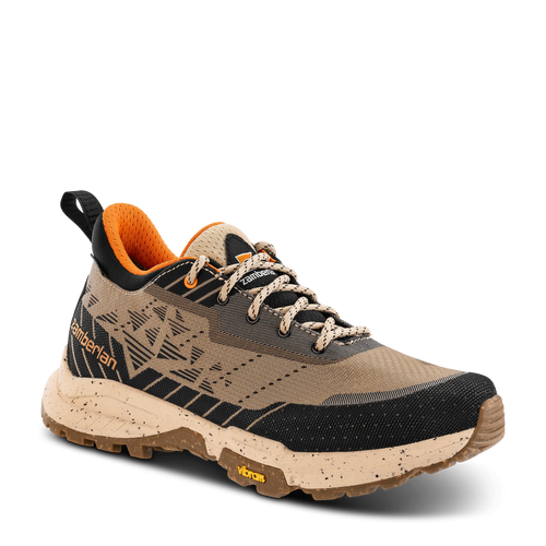 Brown hiking shoe with orange lining on a black background