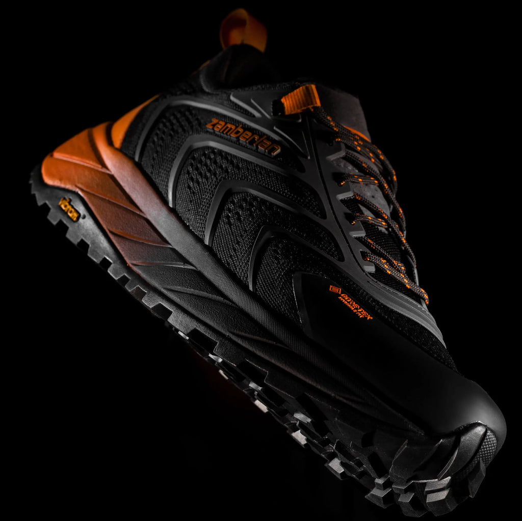 Black and orange hiking shoe on a black background