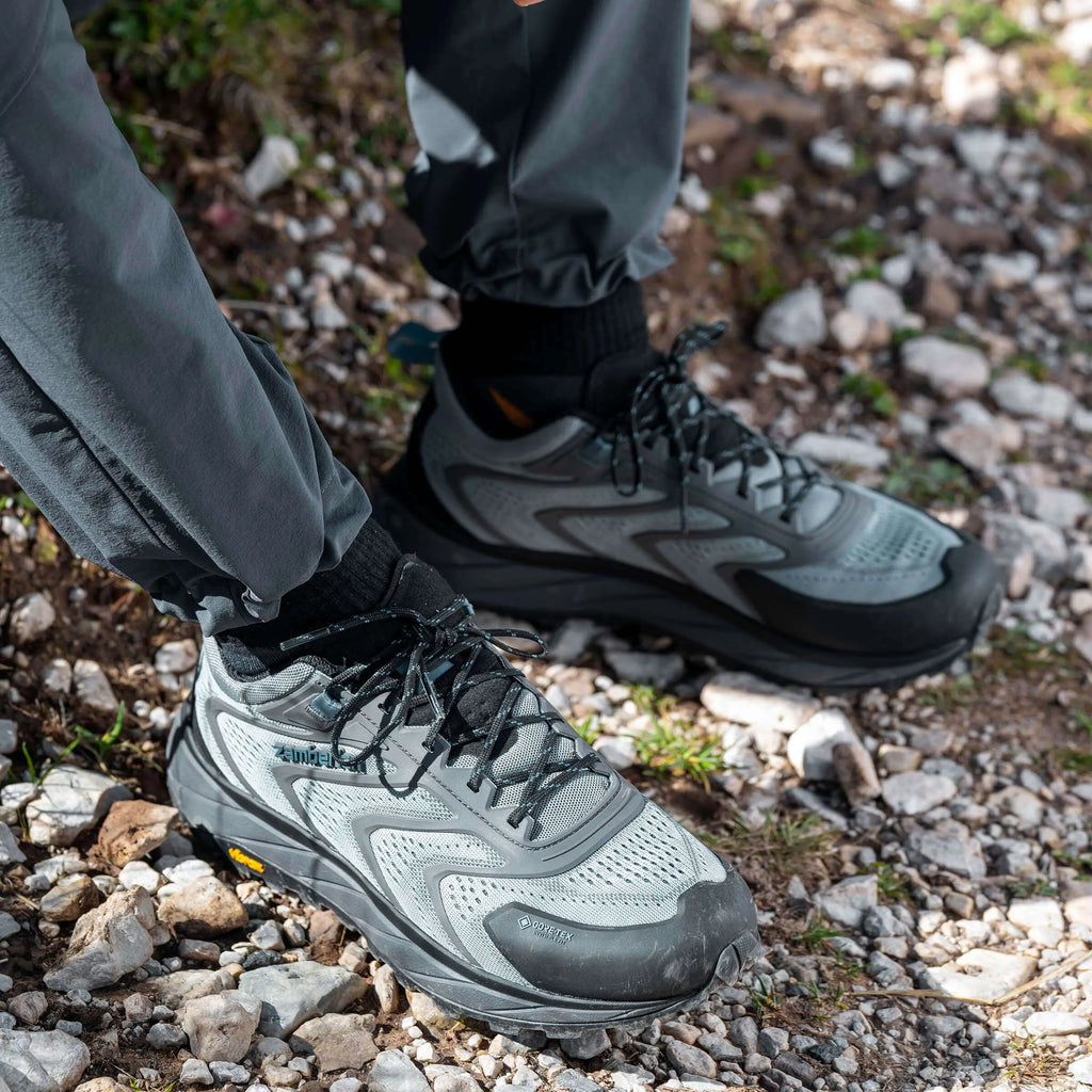 Person wearing gray hiking shoes on a rocky trail