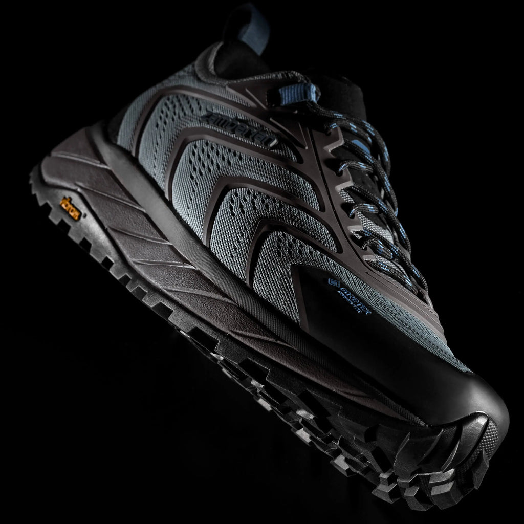 Black hiking shoe with textured sole on a black background