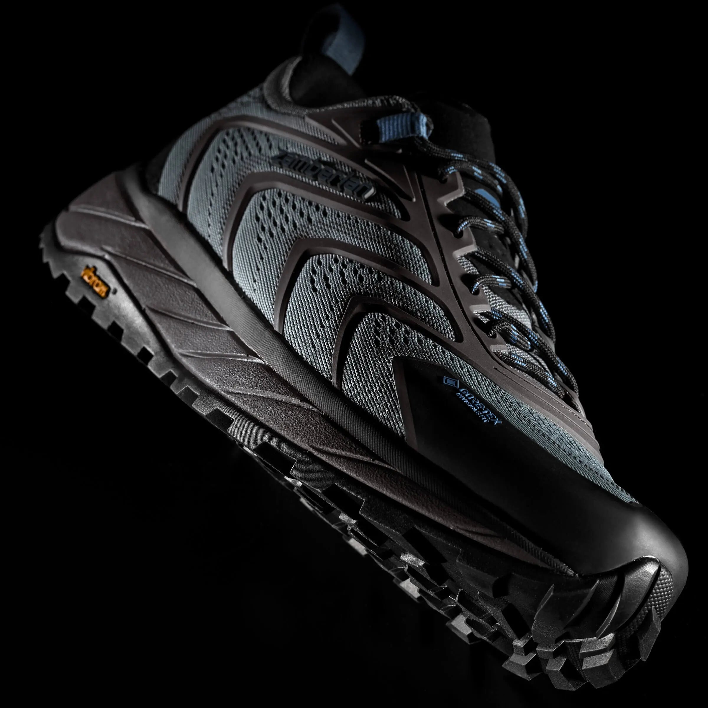 Black hiking shoe with textured sole on a black background