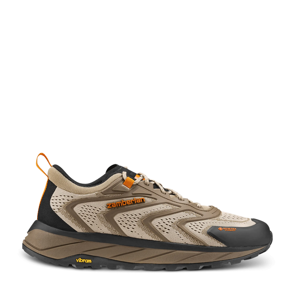 Beige and black running shoe with orange accents on a white background