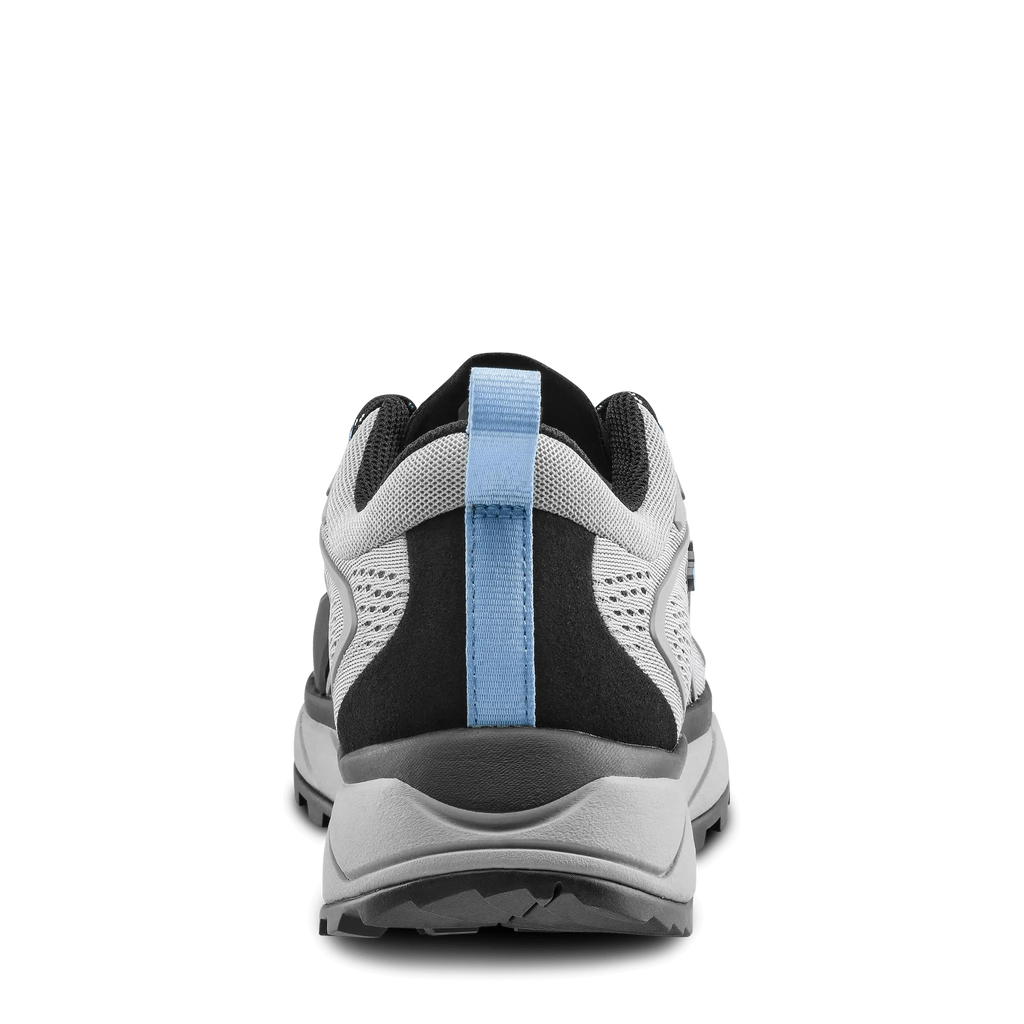 Back view of a black and white athletic shoe with a blue strap on a black background