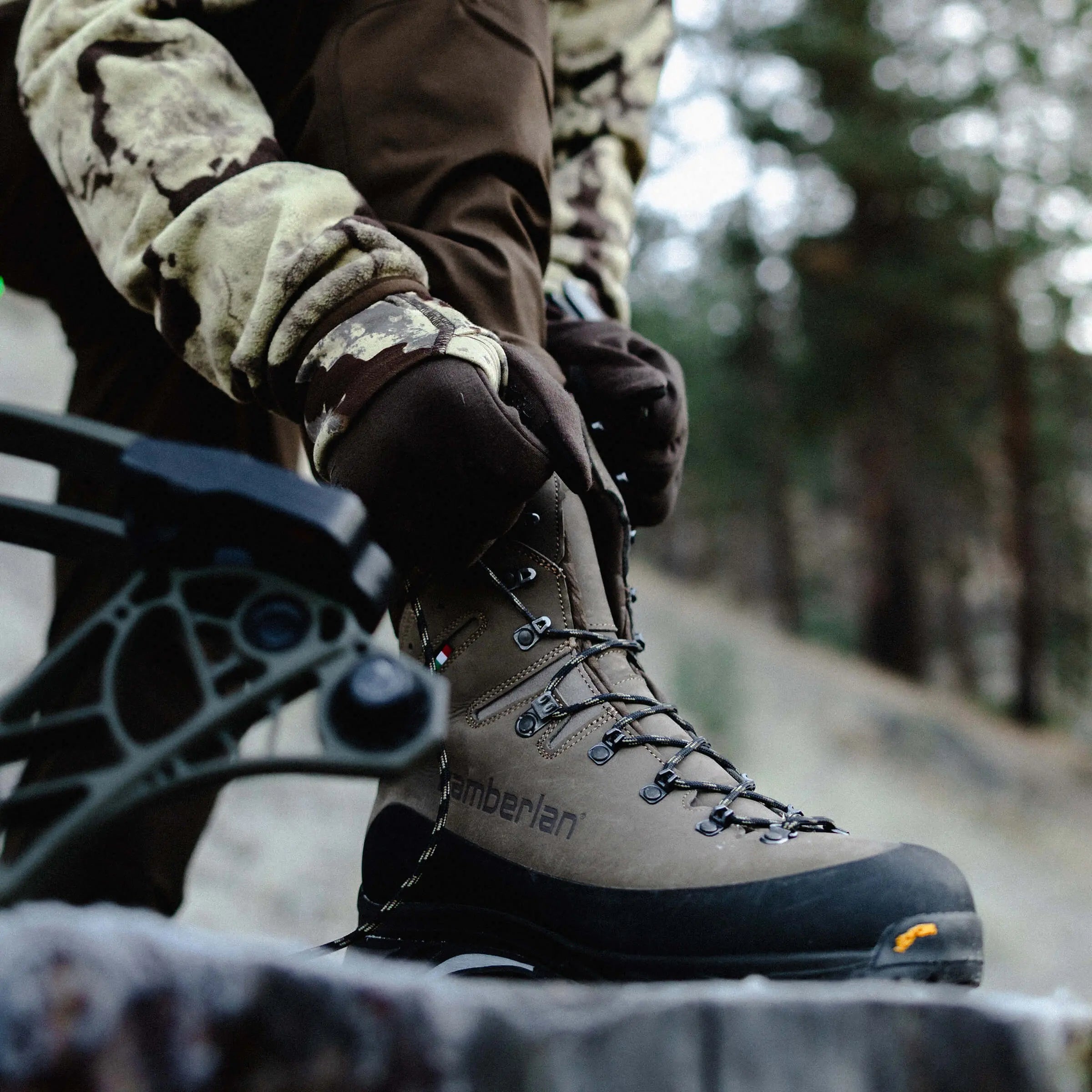 Person wearing a hiking boot with 'Zamberlan' branding in a forest setting.