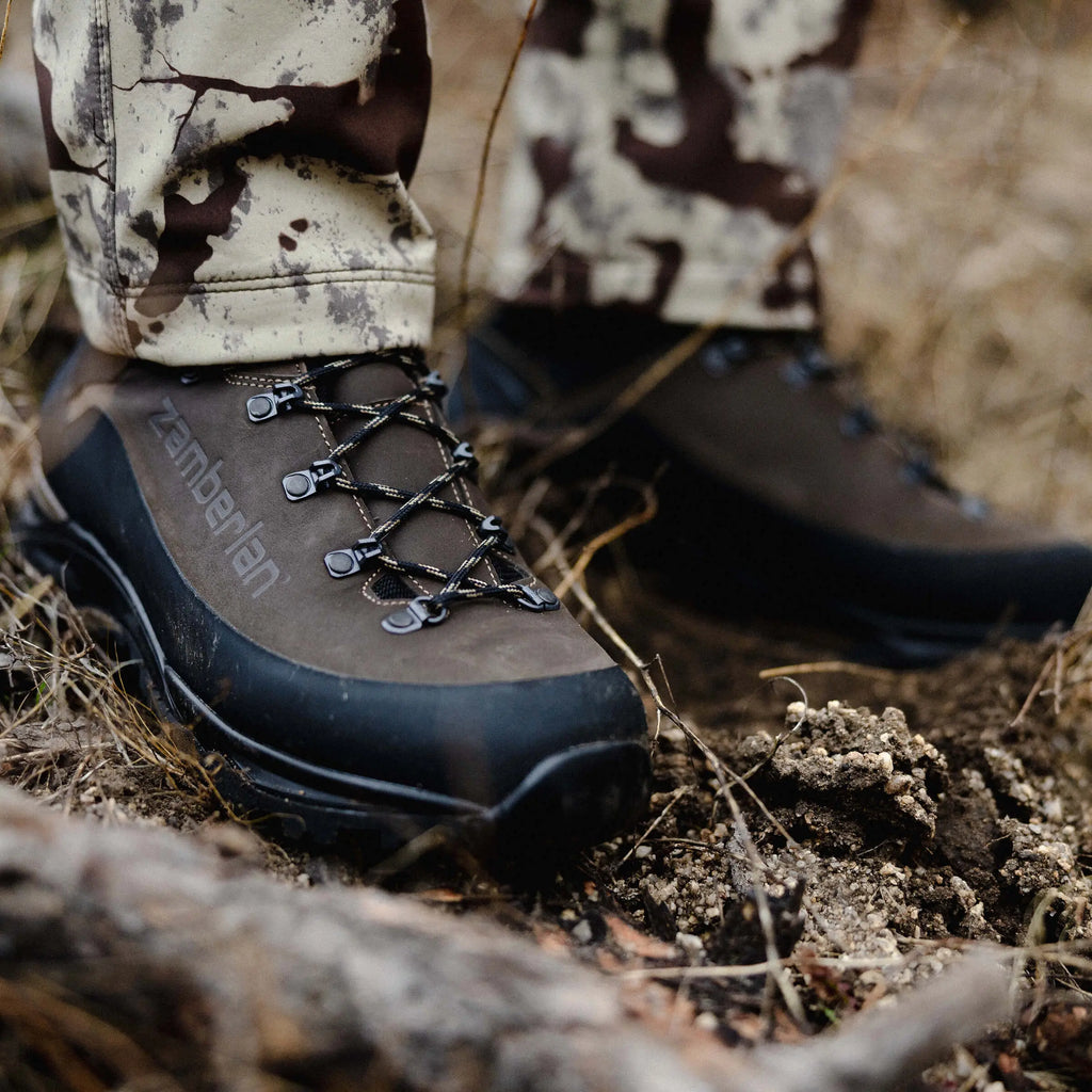 Close-up of a hiking boot with laces on a natural ground background