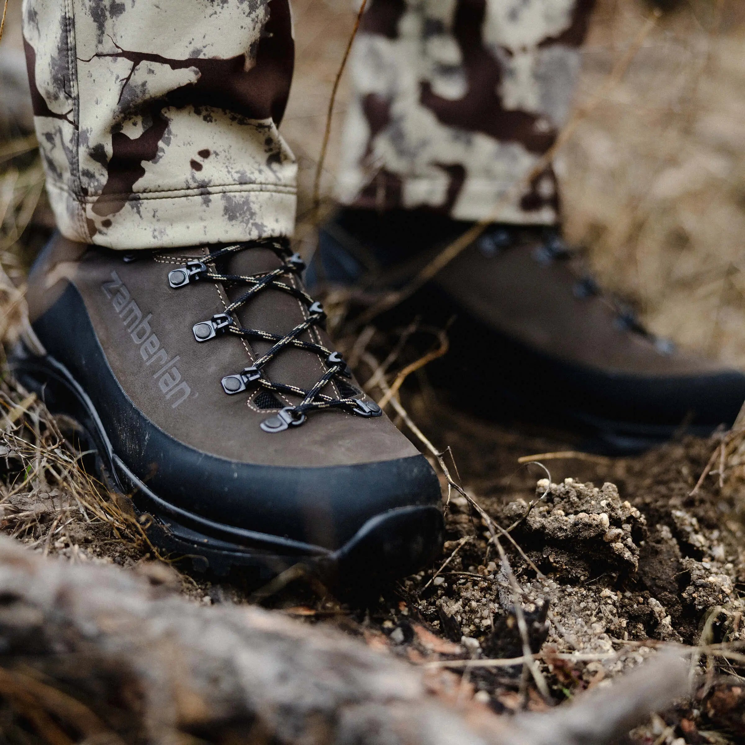 Close-up of a hiking boot with laces on a natural ground background