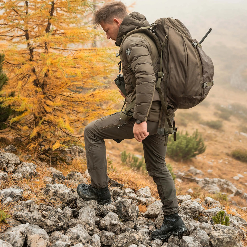 Person hiking on a rocky trail with autumn foliage