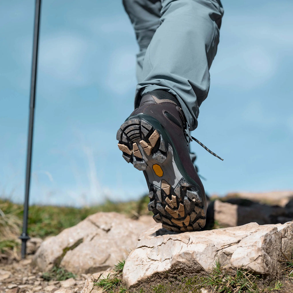 Hiking boot on a rocky surface with a clear blue sky