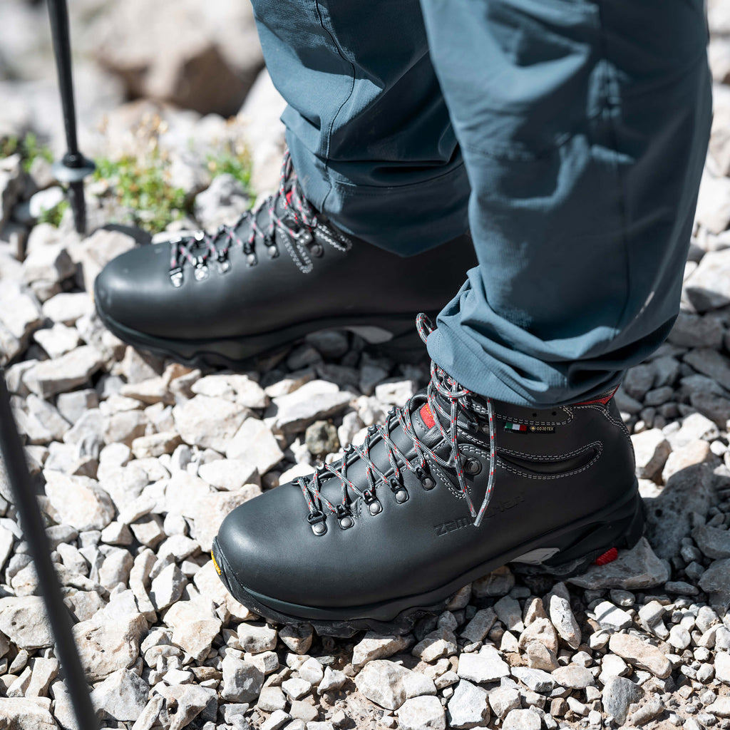 Black hiking boots on a rocky ground