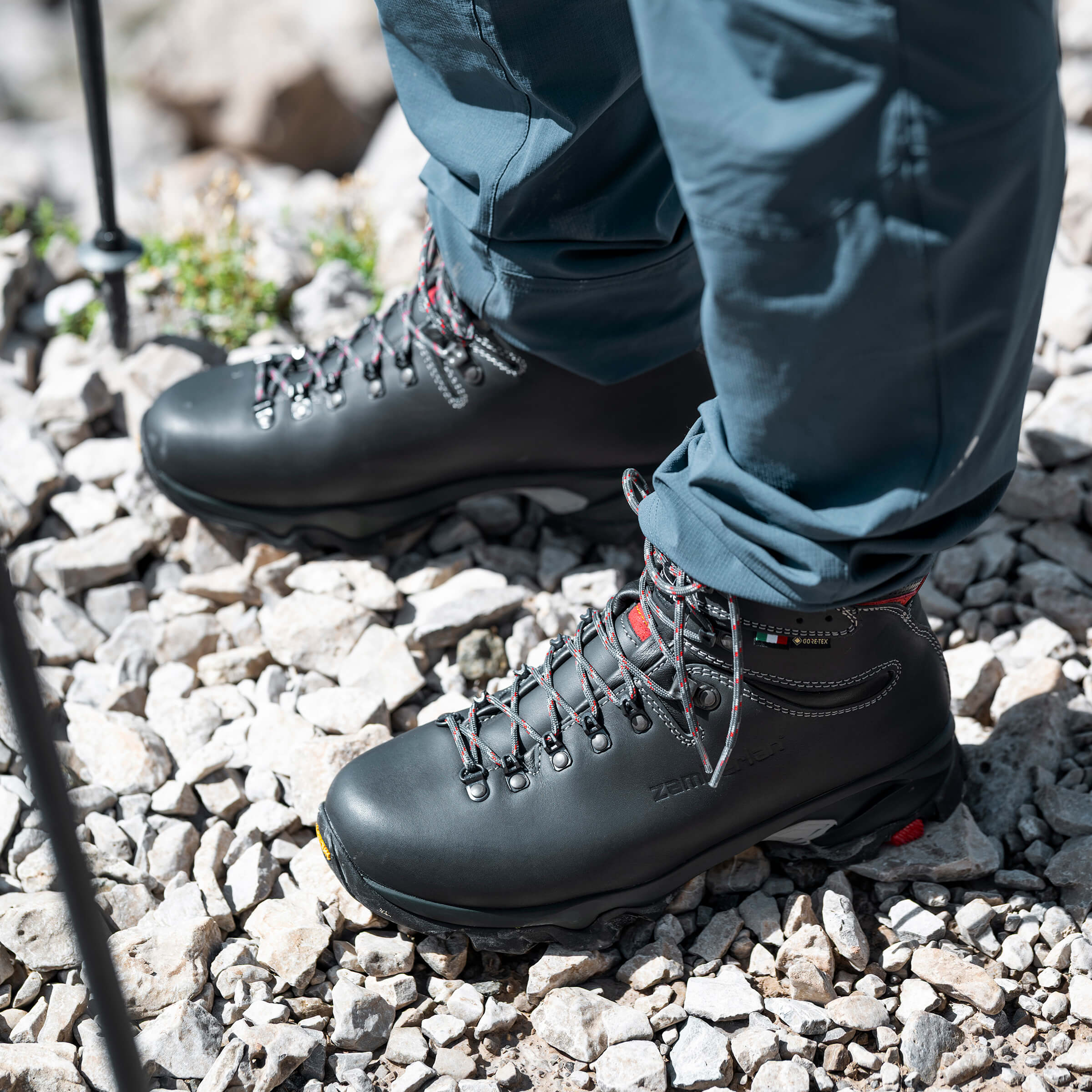 Black hiking boots on a rocky ground