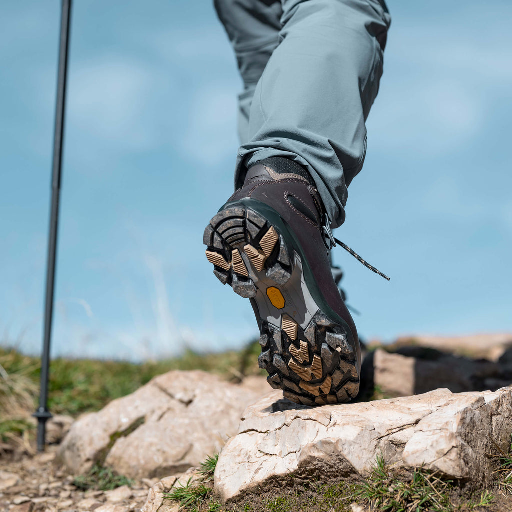 Hiking boot on a rocky surface with a clear blue sky