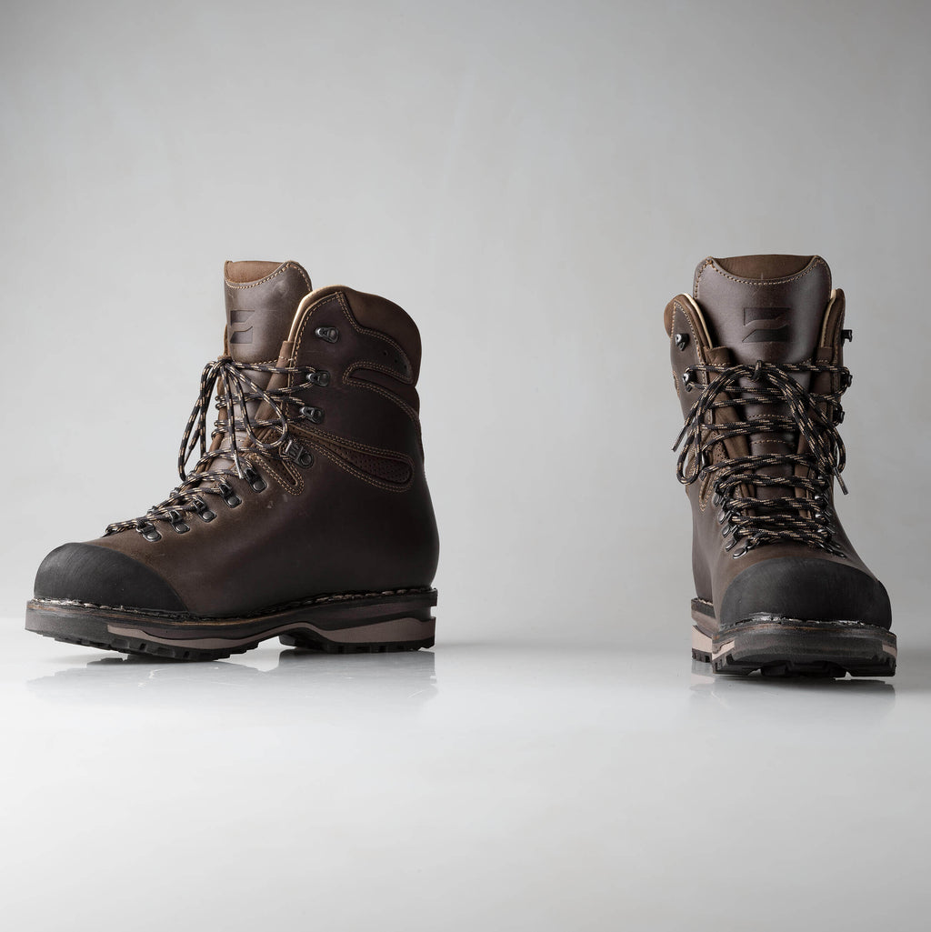 Pair of brown hiking boots on a light gray background