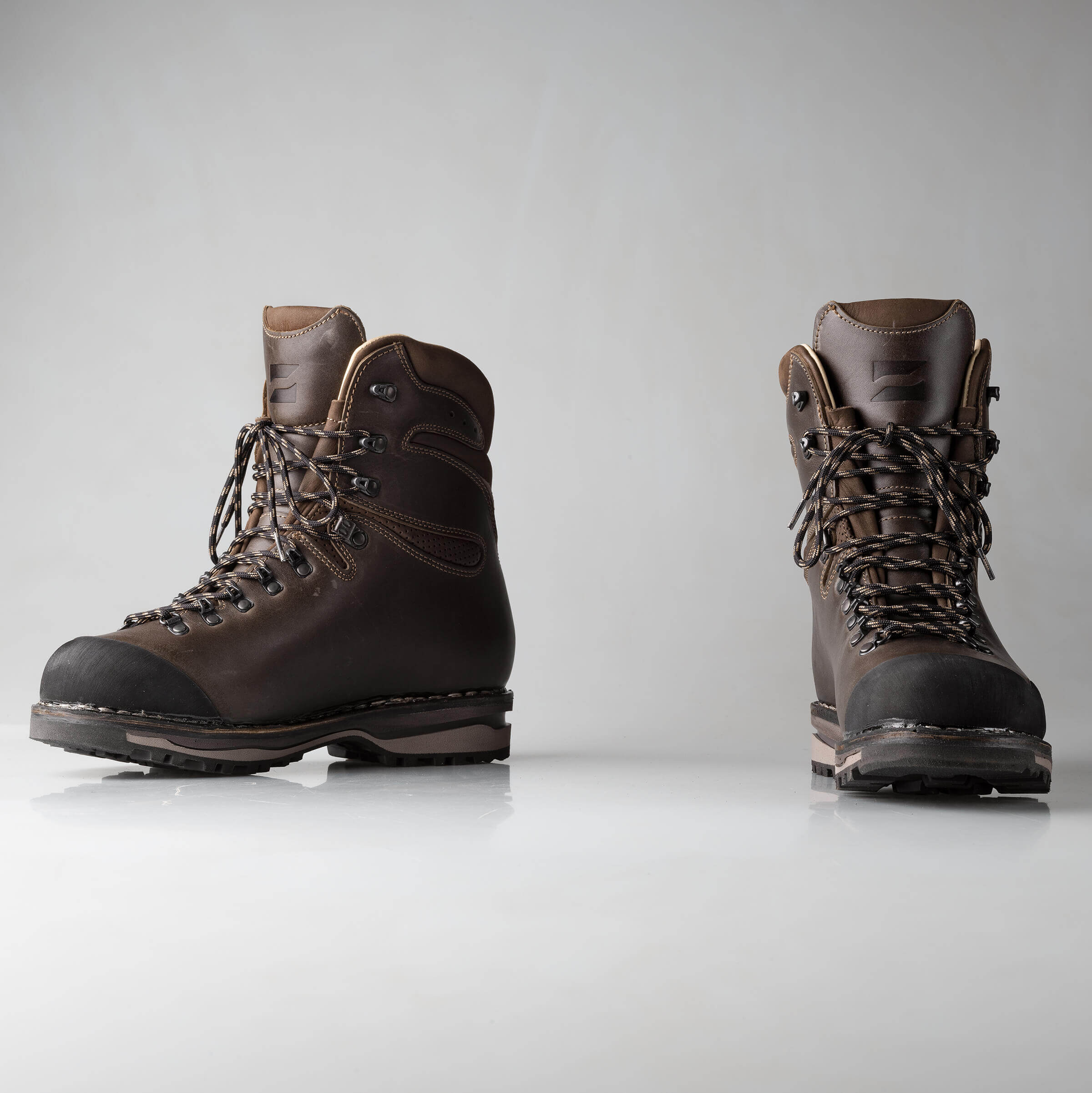 Pair of brown hiking boots on a light gray background