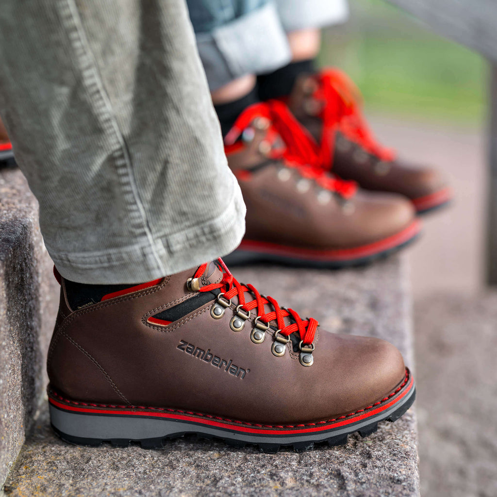 Brown hiking boots with red laces and Zamberlan branding on a stone surface.