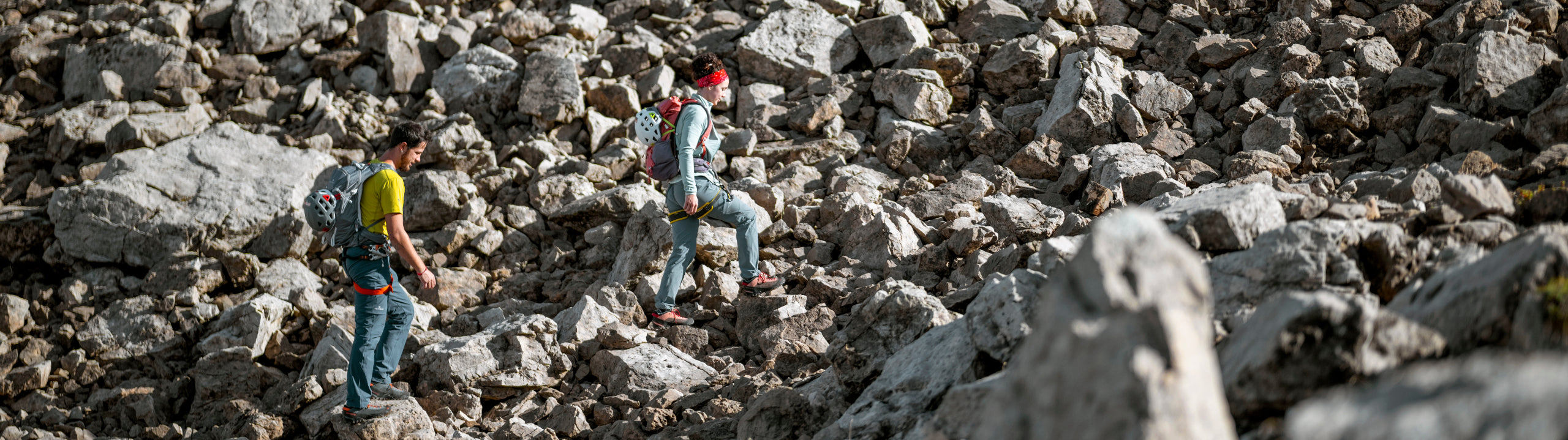 Two people hiking on a rocky mountain trail