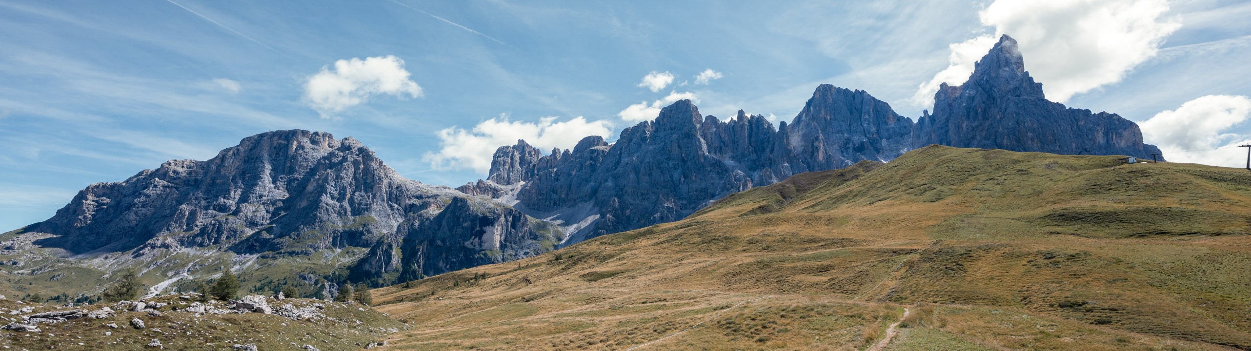 Scenic view of mountain range with green grass and blue sky